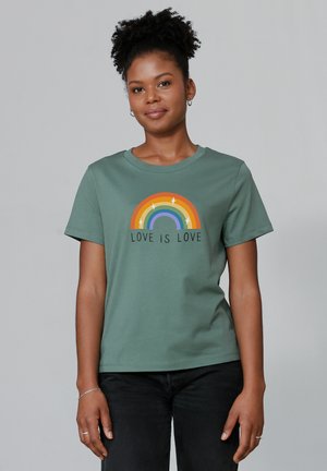 Groene katoenen t-shirt met een kleurrijke regenboogafbeelding en de tekst "LOVE IS LOVE" eronder. Korte mouwen en een ronde hals.