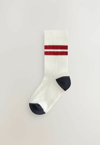 Weißer gerippter Socke mit zwei roten horizontalen Streifen, einer blauen Zehe und Ferse sowie einer glatten Textur. Standardmäßiges Sportdesign.
