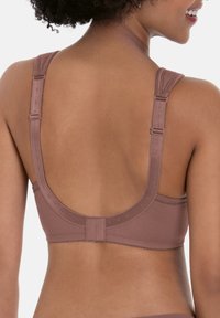 Sujetador inalámbrico color malva con tirantes anchos, textura suave y cierre de gancho. Presenta un diseño de espalda redondeada y detalles de costura sutiles.