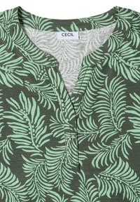 Chemise verte avec motif de feuilles vert clair, col rond avec patte de boutonnage partielle à l'avant et une étiquette « CECIL » à l'intérieur du col.