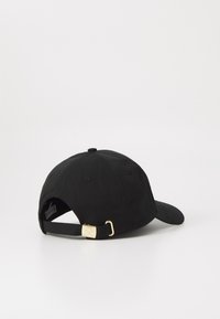 Svart baseballcaps med buet skygge, justerbar stropp bak og gullfarget detalj. Laget av stoff med en glatt tekstur.