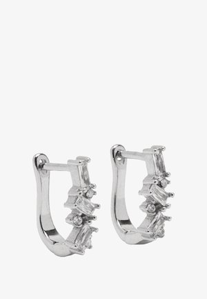 Srebrne kolczyki w kształcie kół, zdobione prostokątnymi i okrągłymi przezroczystymi kamieniami osadzonymi z przodu, o gładkim, błyszczącym wykończeniu i minimalistycznym designie.