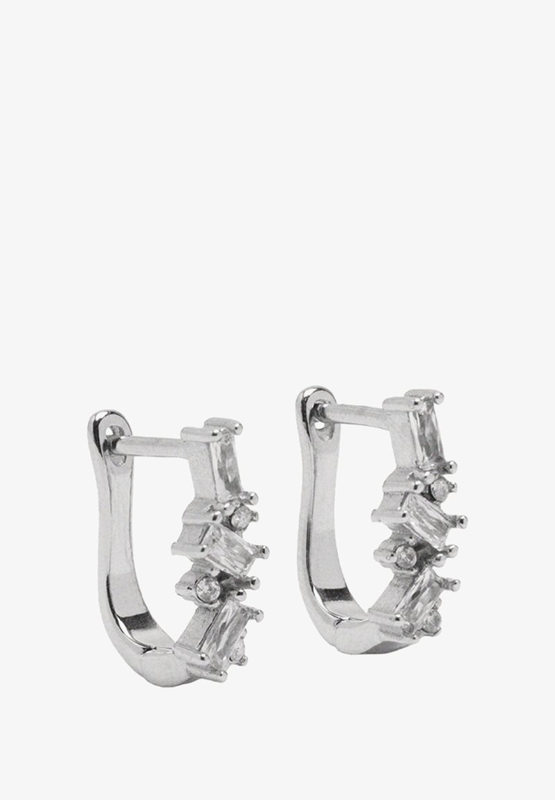Srebrne kolczyki w kształcie kół, zdobione prostokątnymi i okrągłymi przezroczystymi kamieniami osadzonymi z przodu, o gładkim, błyszczącym wykończeniu i minimalistycznym designie.