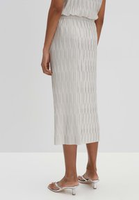 Plissé midi rok in lichtgrijs met verticale strepen; elastische tailleband; soepele textuur; gecombineerd met zilveren hakken.