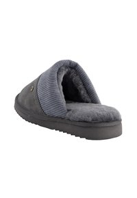 Grijze slipper met een zachte, pluche binnenkant, ribbelstof bovenkant, platte zool en decoratieve stiksels, ontworpen voor comfort en warmte.