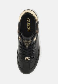 Black leather sneaker with gold accents, textured design, gold logo on tongue, black laces, and white rubber sole. Top view.