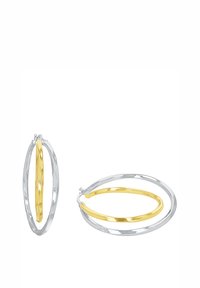 Ett par tvåfärgade creoler med en större silverring som omger en mindre guld-ring, en örhänge stående och en liggande platt.