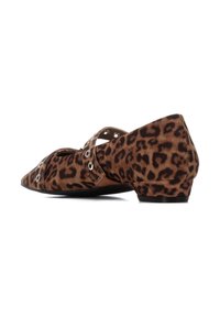 Zapatos planos de estampado de leopardo con punta afilada, tacón bajo y diseño con cortes. Cuenta con detalles de metalplateado en las correas. Textura de ante.