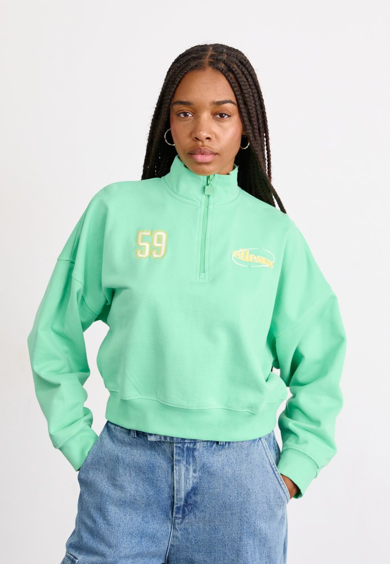Felpa verde menta con zip e collo alto, grande numero ricamato 59 e dettagli con logo. Vestibilità comoda con orlo e polsini a costine.