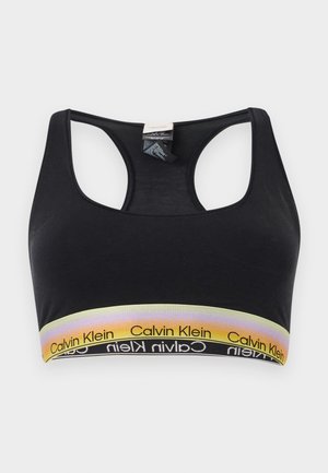 Reggiseno sportivo nero con schiena a racerback e fascia elastica gialla sfumata con loghi Calvin Klein ripetuti.