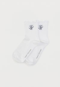 Λευκές κάλτσες αστραγάλου από βαμβακερό μείγμα. Ριμπ ύφανση με κυματοειδές πάνω άκρο. Κέντημα με λογότυπο σε σ κουρομπλε στο πλάι. Το όνομα της μάρκας τυπωμένο στη σόλα.