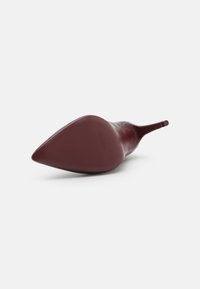 Burgundi kõrge kontsaga kingad, millel on terav nina ja tekstureeritud põhi. Sile pealmine materjal, elegantne disain ja pikendatud siluett.