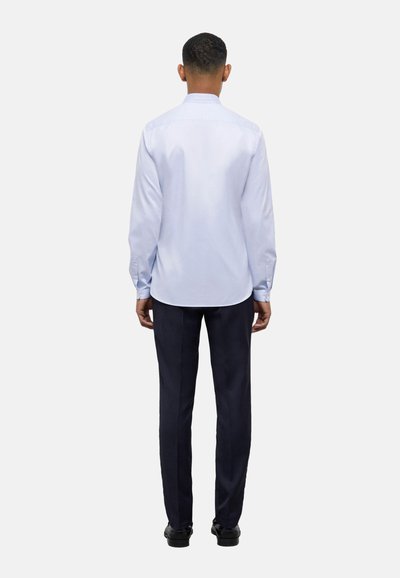 Camicia azzurra a maniche lunghe con colletto button-down, indossata con pantaloni blu scuro. Tessuto liscio e vestibilità standard. Vista posteriore mostrata.