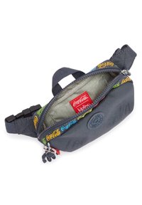 Marsupio nero con stampa del logo colorato Coca-Cola sulla cerniera, etichetta del marchio Kipling all'interno e un piccolo portachiavi attaccato alla linguetta della cerniera.