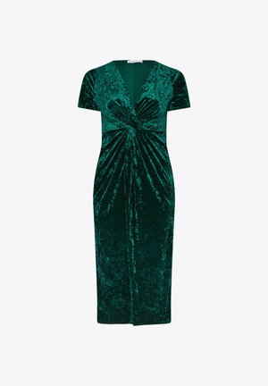 Abito in velluto verde smeraldo con scollo a V profondo, maniche corte e design frontale intrecciato. Lungo fino al ginocchio con una silhouette aderente.