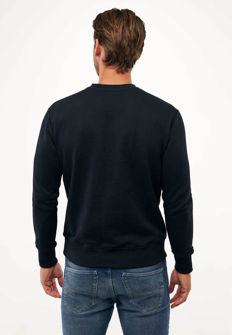 Czarna bluzka z okrągłym dekoltem i długimi rękawami, wykonana z gładkiego materiału. Tył ma prosty design bez grafik.