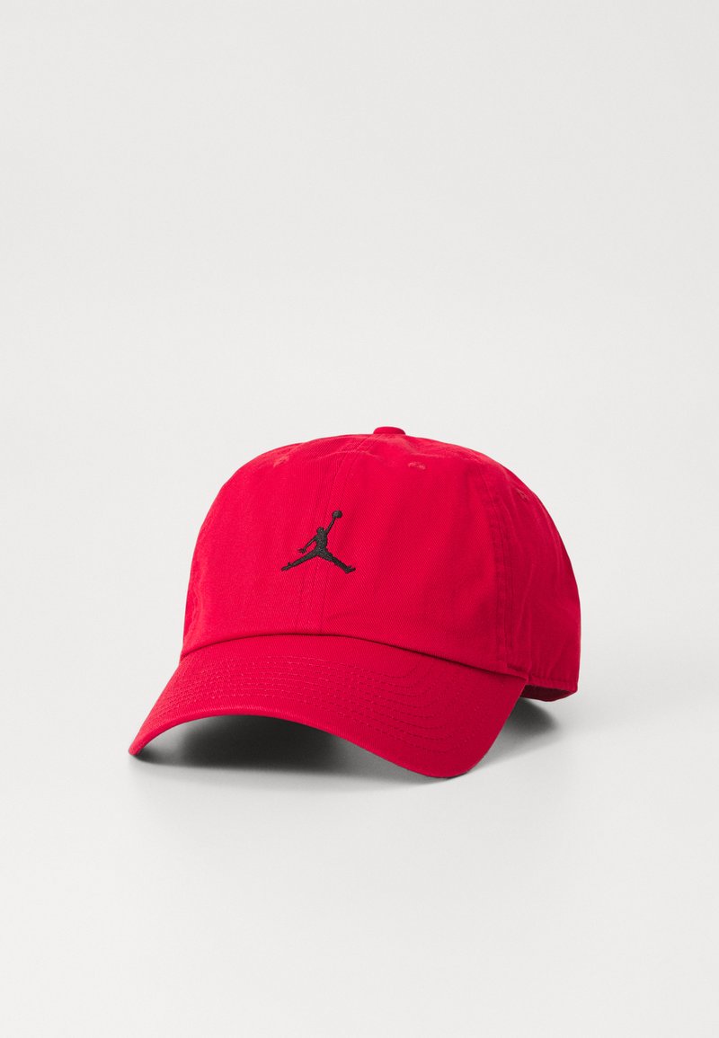 Sarkans kokvilnas beisbola cepure ar izliekto malu, uz kuras priekšējās puses ir melns Jordan logotips. Strukturēta kronis ar šuvju detaļām.