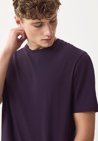 Lilla kortærmet t-shirt lavet af blødt stof med rund halsudskæring og glat tekstur. Minimalistisk design uden mønstre eller accenter.