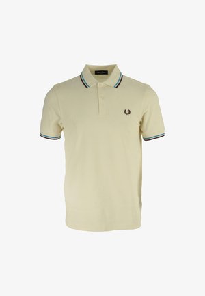 Polo shirt jaune clair avec un plastron à deux boutons, un col rayé vert et bordeaux, et un petit logo brodé sur la poitrine gauche.
