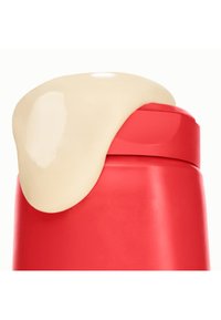 Punainen pullo, jossa on sileä ja kiiltävä pinta, jonka päällä on vaaleanruskea kermakupla. Suunnittelussa on pyöristetty korkki ja kaareva reuna.