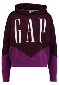 Felpa con cappuccio color marrone e viola con maniche ampie, caratterizzata da un grande logo bianco "GAP" sul davanti e un design a blocchi di colore diagonali.