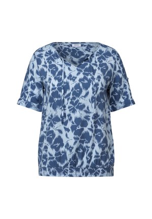 Blå kortærmet top med et abstrakt mønster i varierende nuancer af blå, med V-udskæring, snore detaljer og elastisk kant.