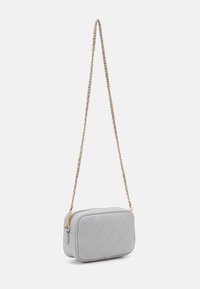 Varrt szürke keresztpántos táska téglalap alakú, arany láncot tartalmazó pánttal és cipzáras zárással. Simább textúrával és finom varrás részletekkel rendelkezik.