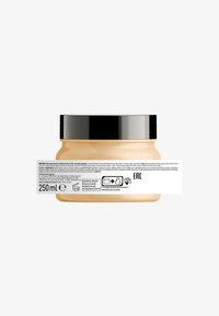 Clear glass jar with a black lid, containing a light beige product. Back label displays instructions and recycling symbols. 250 ml capacity.