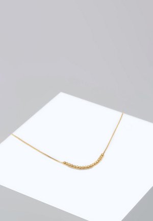 Gold chain necklace featuring a delicate design with small spherical beads along one section, on a white display surface.