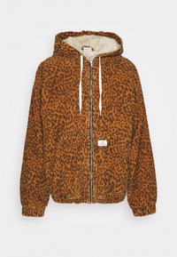 Lahjakku, jossa on leopardikuosi oranssina ja mustana, sisältää hupun, kiristysnauhat, etutaskun ja ribatut hihansuut. Rakenne on teksturoitu.