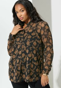 Mustat läpikuultava paita, jossa on monimutkainen kultainen kukkakuvio, napitus edessä, pitkät hihat ja kaulus. Sujuva rakenne, vartalonmyötäinen malli.