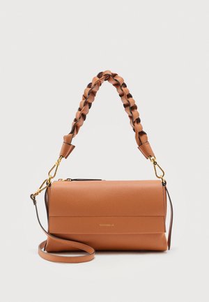 Skulderveske i lyst skinn med teksturert flettet håndtak, gullfarget utstyr og avtakbar lang stropp på ensfarget bakgrunn.