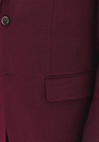 Bordowa marynarka z teksturowanej tkaniny, z pojedynczym guzikiem, kieszenią na piersi oraz boczną kieszenią, o dopasowanym fasonie.