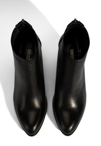 Bottes courtes en cuir noir avec un bout pointu et un design élégant. Dotées d'une fermeture éclair à l'arrière et d'une texture lisse.