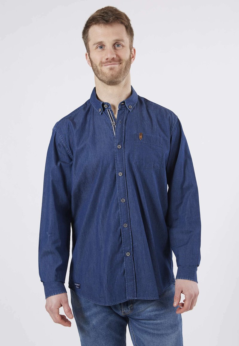 Chemise en denim bleu à manches longues avec col boutonné, poche poitrine et petit logo. Caractérisée par une coupe relaxe et une texture douce.