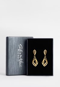 Guldörhängen med en intrikat, öppen design som har ett diamantmönster och små klara stenar. Presenterades i en mörk låda.