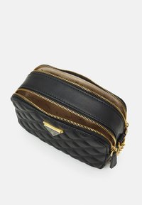 Schwarze, gep quiltete Kosmetiktasche aus Leder mit goldenen Reißverschlüssen. Verfügt über zwei Fächer und eine Metall-Logo-Plakette auf der Vorderseite. Glatte Textur.
