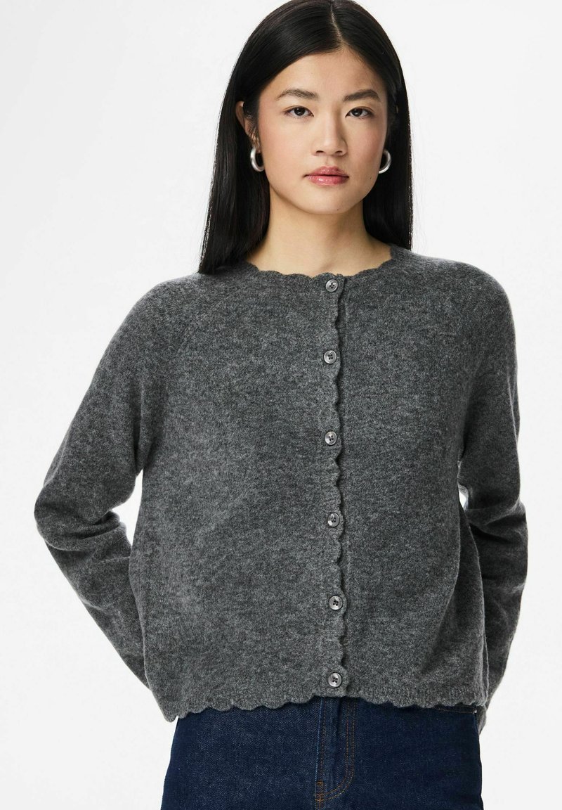 Pelēks adīts kardigans ar viļņotu apakšmali un apaļu kakla izgriezumu, priekšpusē pieci pogas, izgatavots no mīksta materiāla.