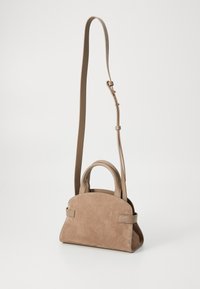 Tan suede handbag with a structured shape, two top handles, and a long adjustable strap. Features minimalist design with no visible logos.