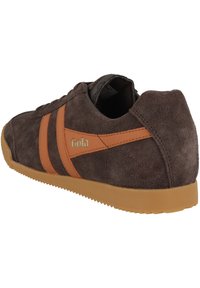 Sneaker in suede marrone con strisce arancioni e logo, dotato di suola in gomma e parte superiore texture per una presa e durabilità migliori.