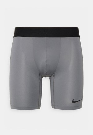 Hallid spordipüksid musta elastse vöökohaga, millel on sile tekstuur ja väike must logo alumisel vasakul küljel.