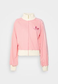 Rosa gekürzte Jacke mit einem gerippten weißen Kragen und Bündchen. Verfügt über einen Reißverschluss vorne und drei weiße Streifen, die entlang der Ärmel verlaufen. Besticktes Logo.