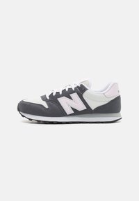 Buty sportowe New Balance w kolorach szarym, białym i różowym. Wykonane z zamszu i siateczki, z zaokrąglonym noskiem oraz amortyzowaną podeszwą z przyczepnością.