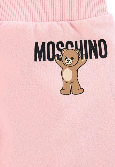 Różowa bawełniana tkanina z grafiką kreskówkowego niedźwiedzia oraz napisem "MOSCHINO" w kolorze czarnym. Projekt zawiera żeberkowe akcenty w talii.