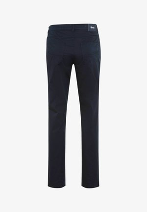 Pantalon slim bleu marine foncé avec poches arrière et patch logo Brax sur la ceinture, présenté de dos sur un fond uni.