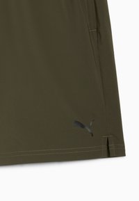 Oliivirohelised lühikesed püksid, millel on sile tekstuur, küljetaskud, õmmeldud servad ja peegeldav must Puma logo vasakul alapoole.