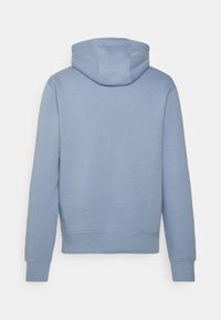 Maglione a pullover blu chiaro con maniche lunghe, polsini e orlo a coste, mostrato da dietro su uno sfondo bianco.