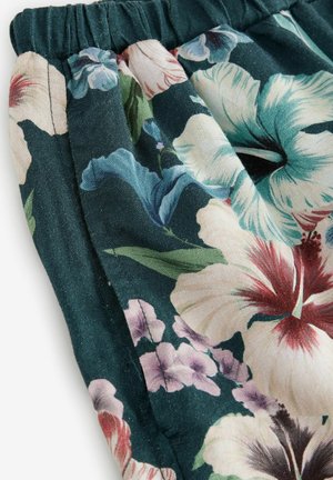 Materiał w kwiatowy wzór w ciemnym teal z dużymi hibiskusami i małymi kwiatami. Posiada marszczoną talię, miękką fakturę oraz delikatny połysk.