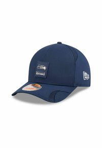 Dunkelblaues Cap mit strukturiertem Design, das auf der Vorderseite ein Patch mit dem Logo der Seattle Seahawks und einen orangefarbenen Aufkleber auf dem Schirm hat.