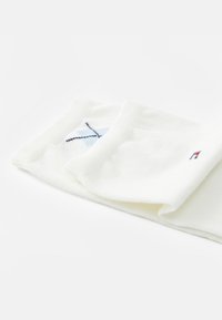 Vita bomullssockor med en ljusblå och marinblå broderad design upptill, med en mjuk textur och en enkel, rullad manschett.